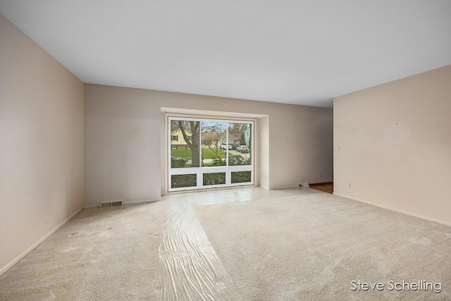 carpeted spare room with baseboards and visible vents