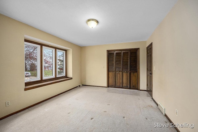 unfurnished bedroom featuring carpet floors, baseboards, and visible vents