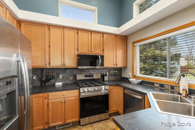 kitchen with stainless steel appliances, visible vents, plenty of natural light, and a towering ceiling