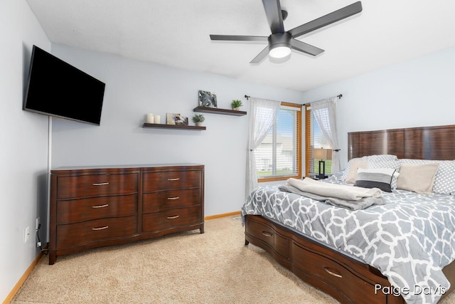 bedroom with a ceiling fan, baseboards, and light colored carpet