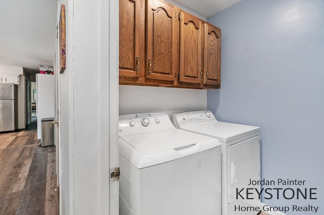 3316 W Lemon Creek Rd, Bridgman, MI 49106 - washroom featuring washing machine and clothes dryer, cabinet space, and wood finished floors