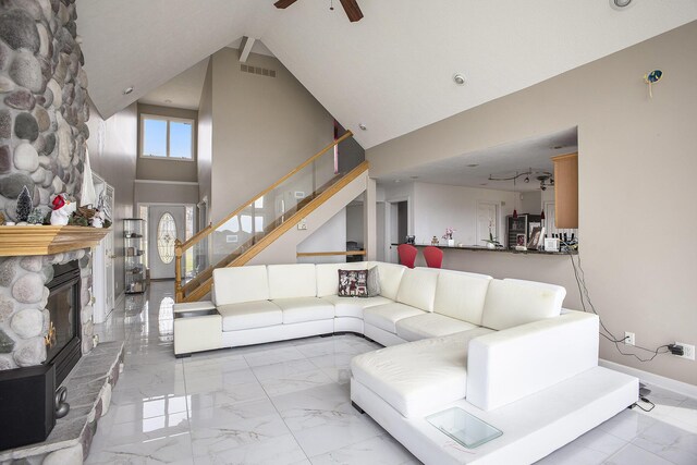 17 Coronado Dr, Jackson, MI 49201 - living area featuring high vaulted ceiling, a ceiling fan, a stone fireplace, stairway, and marble finish floor