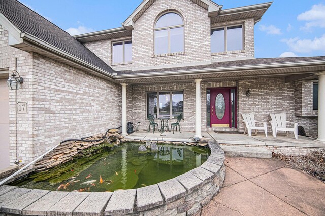 17 Coronado Dr, Jackson, MI 49201 - property entrance with a garden pond and brick siding