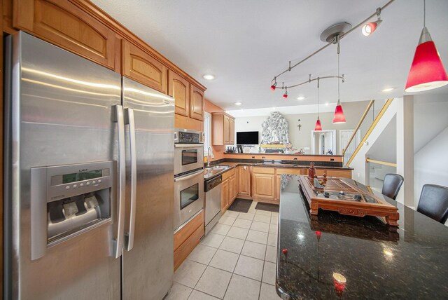 17 Coronado Dr, Jackson, MI 49201 - kitchen with pendant lighting, a peninsula, light tile patterned flooring, a sink, and stainless steel appliances