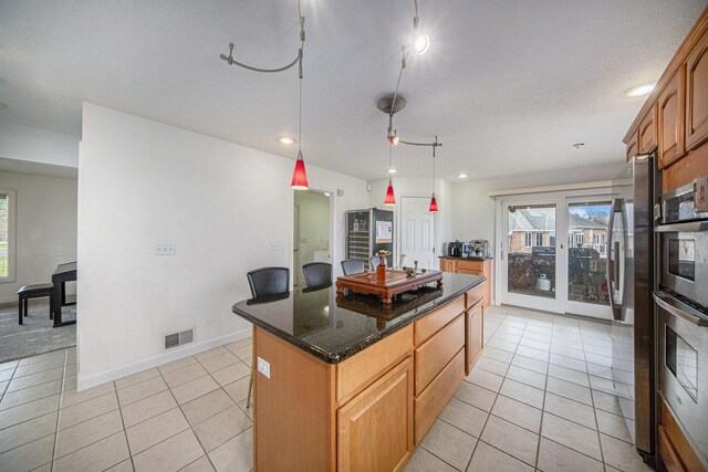 17 Coronado Dr, Jackson, MI 49201 - kitchen with visible vents, a center island, double oven, and light tile patterned floors