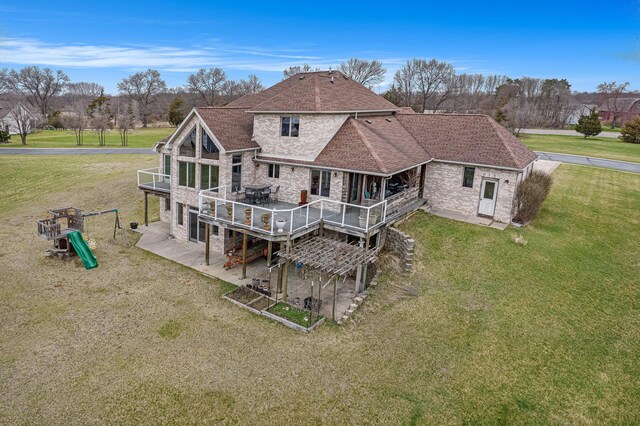 17 Coronado Dr, Jackson, MI 49201 - back of house featuring a patio, a lawn, brick siding, a deck, and a shingled roof
