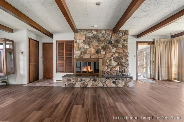 1220 W Green St, Hastings, MI 49058 - unfurnished living room featuring wood finished floors, a stone fireplace, and beam ceiling