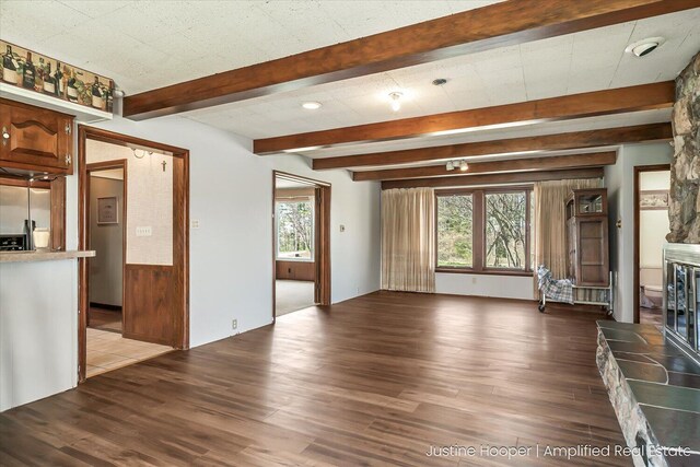 1220 W Green St, Hastings, MI 49058 - unfurnished living room featuring a wealth of natural light, beamed ceiling, and wood finished floors