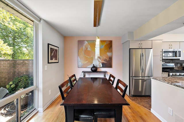 1118 Stafford Pl, Detroit, MI 48207 - dining area featuring a wealth of natural light, light wood finished floors, visible vents, and baseboards