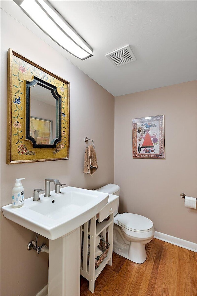 1118 Stafford Pl, Detroit, MI 48207 - bathroom with visible vents, toilet, wood finished floors, and baseboards
