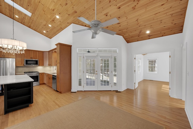 kitchen featuring stainless steel appliances, light wood finished floors, light countertops, and wood ceiling