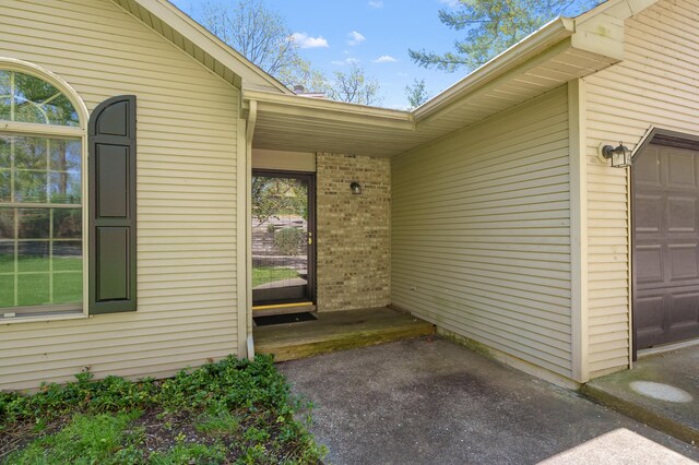 10511 Stoney Point Dr, Delton, MI 49046 - view of exterior entry with brick siding and an attached garage