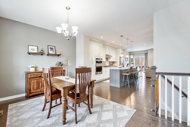 dining room with baseboards, wood finished floors, a chandelier, and recessed lighting