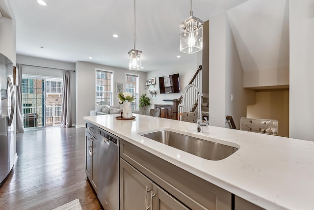 kitchen featuring a sink, open floor plan, recessed lighting, appliances with stainless steel finishes, and hanging light fixtures