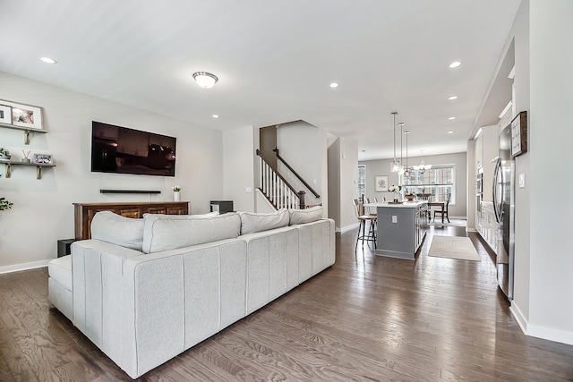 living area featuring baseboards, stairs, dark wood-type flooring, and recessed lighting