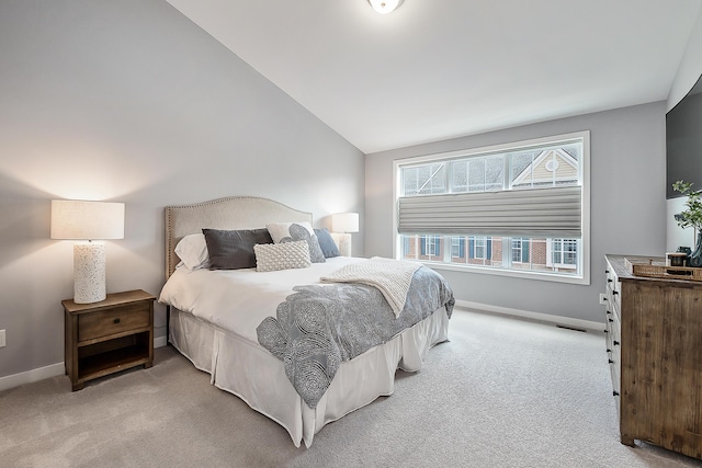 bedroom featuring light carpet, vaulted ceiling, visible vents, and baseboards