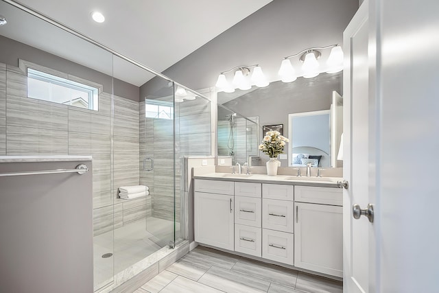 bathroom featuring a sink, double vanity, and a stall shower