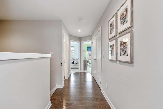 hallway featuring dark wood-type flooring, baseboards, and recessed lighting