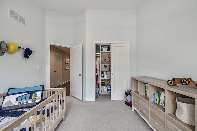 carpeted bedroom featuring baseboards, visible vents, and a closet