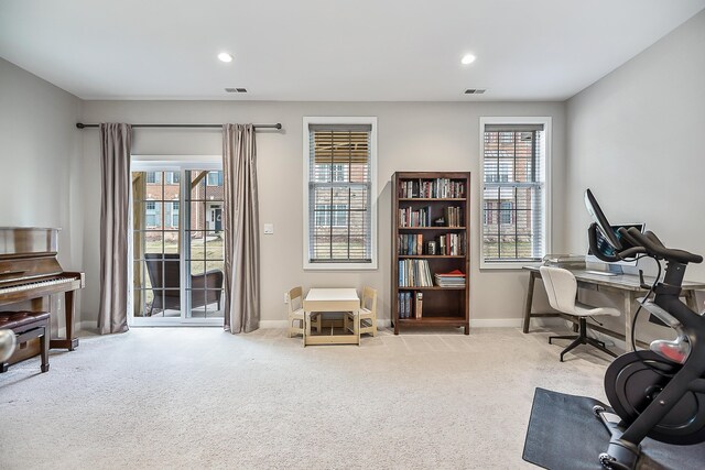 carpeted office space with plenty of natural light, visible vents, and baseboards