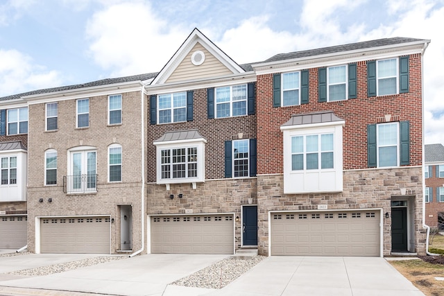 view of front of house with brick siding, driveway, stone siding, and a garage