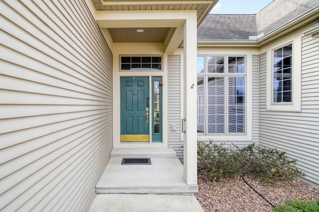 doorway to property featuring roof with shingles