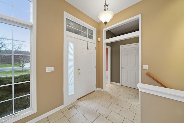 foyer entrance featuring visible vents, baseboards, and light tile patterned flooring
