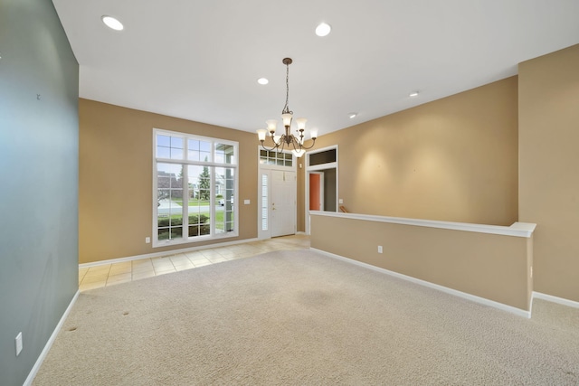 carpeted empty room with tile patterned flooring, baseboards, recessed lighting, and a chandelier