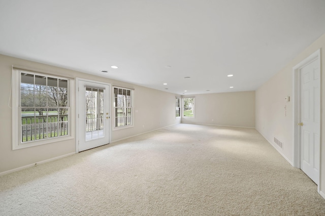 spare room featuring recessed lighting, carpet flooring, visible vents, and baseboards