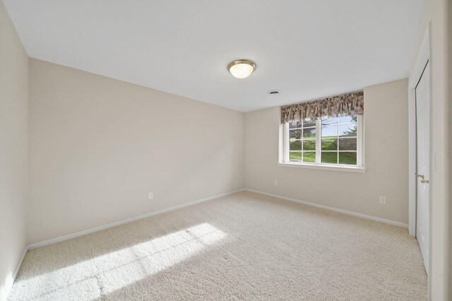 unfurnished bedroom featuring a closet, light colored carpet, and baseboards