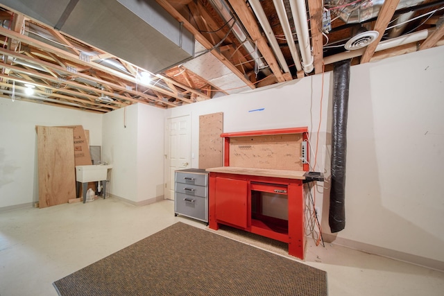 unfinished below grade area featuring baseboards, a workshop area, and visible vents