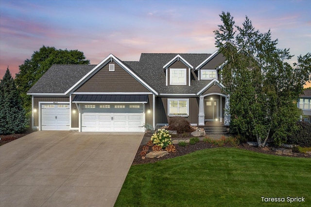 craftsman-style house featuring a standing seam roof, a garage, a lawn, metal roof, and driveway