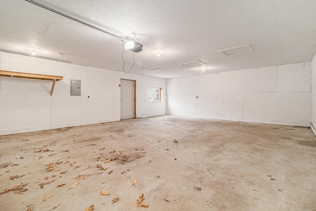 garage with a garage door opener and electric panel