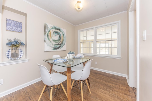 dining room featuring baseboards, ornamental molding, and wood finished floors