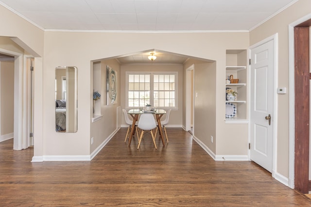 dining space featuring baseboards, crown molding, and dark wood finished floors