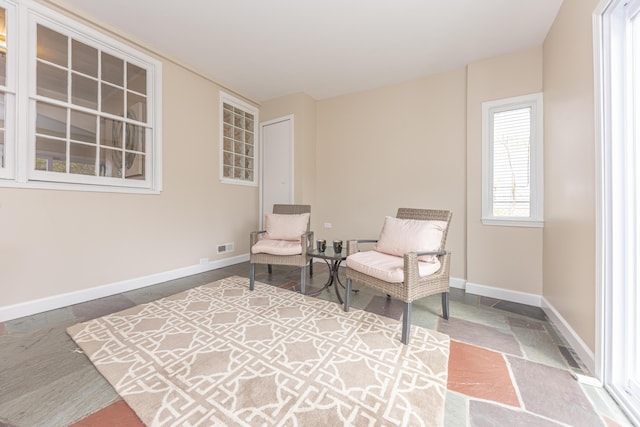 living area with visible vents and baseboards
