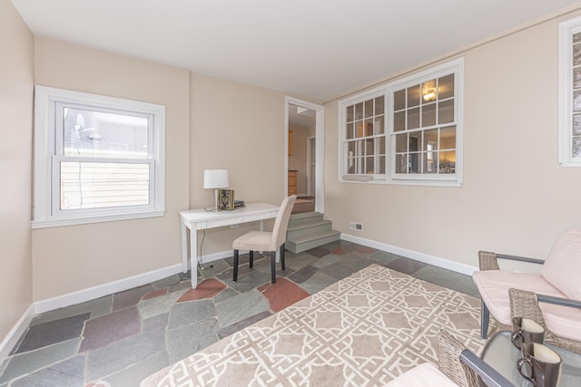 office featuring visible vents, baseboards, and stone tile flooring