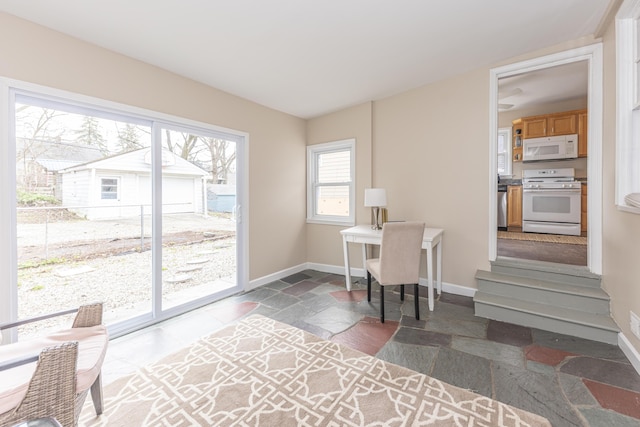 office area with stone tile flooring and baseboards