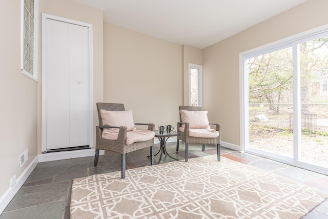 living area with baseboards and visible vents