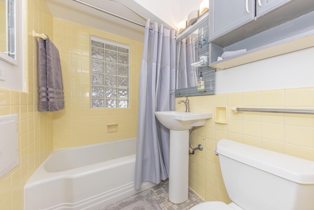 full bath featuring toilet, shower / bath combination with curtain, tile patterned flooring, and tile walls