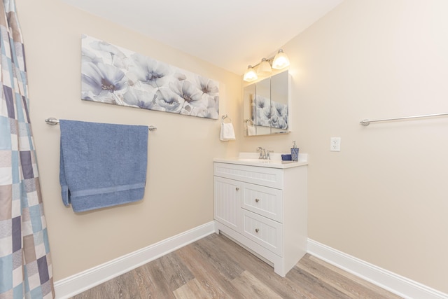 bathroom featuring vanity, baseboards, and wood finished floors
