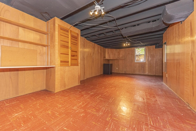 basement with tile patterned floors and wood walls