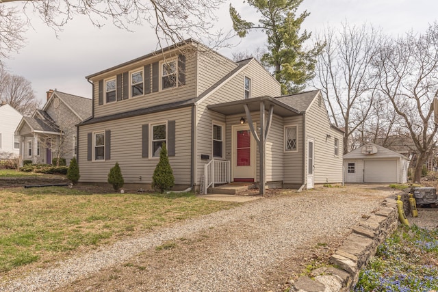bungalow with gravel driveway, an outdoor structure, a detached garage, and a front yard