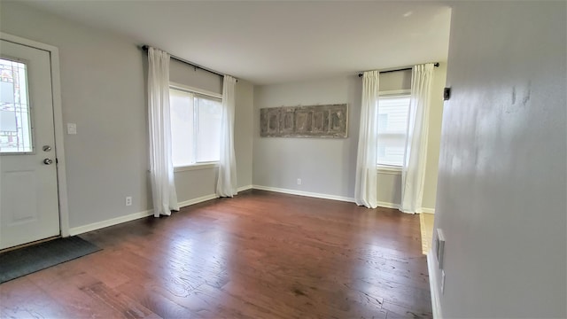 foyer featuring dark wood-type flooring and baseboards