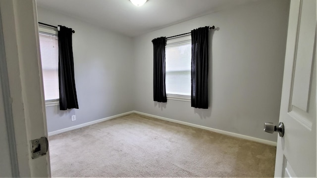 unfurnished room featuring carpet flooring and baseboards