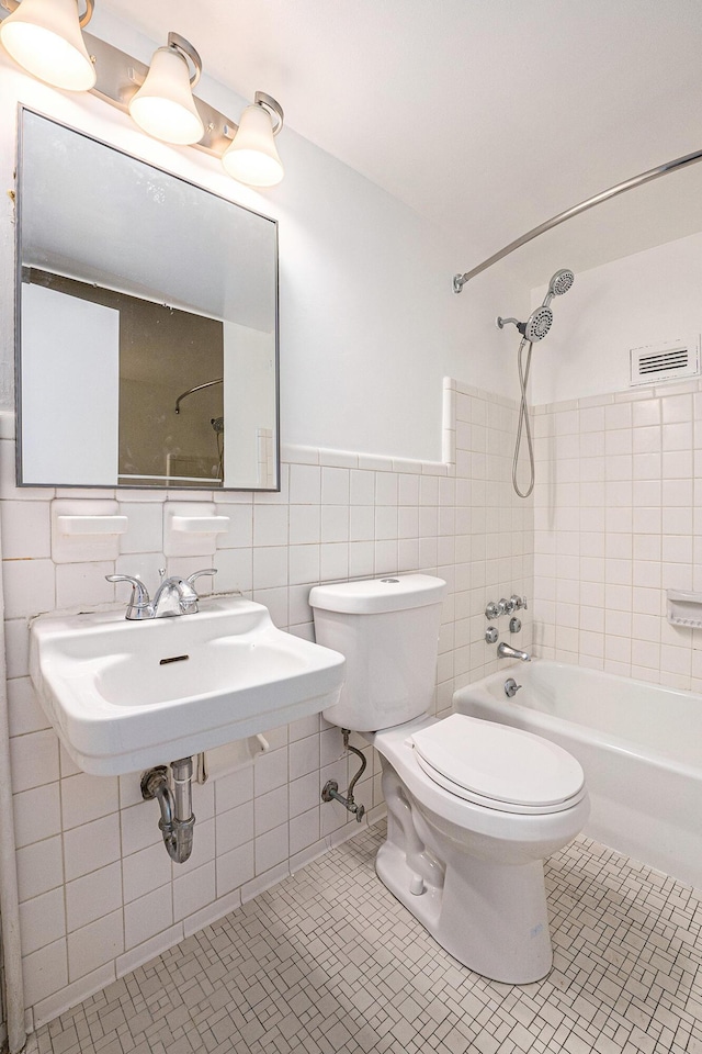 8900 E Jefferson Ave Unit 1109, Detroit, MI 48214 - bathroom featuring bathing tub / shower combination, visible vents, toilet, wainscoting, and tile walls