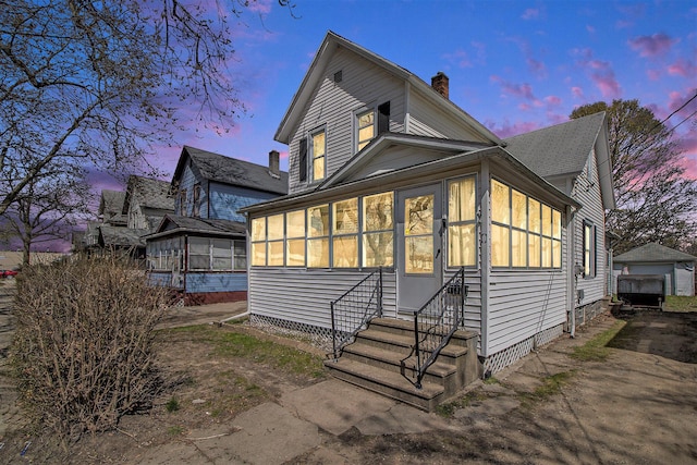 718 Harrison St, Kalamazoo, MI 49007 - view of front of property featuring entry steps, a chimney, and a sunroom