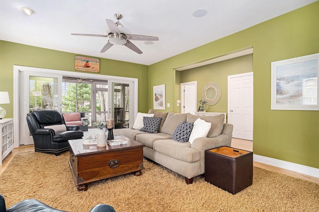 living room featuring baseboards, a ceiling fan, and wood finished floors