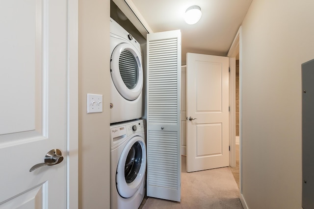 laundry area with light carpet, stacked washer / drying machine, and laundry area