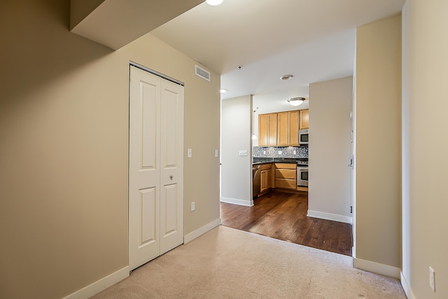 kitchen with dark countertops, tasteful backsplash, baseboards, appliances with stainless steel finishes, and visible vents